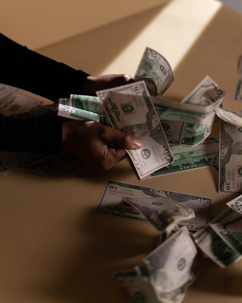 Hands holding and spreading dollar bills in soft natural light showing currency concept.