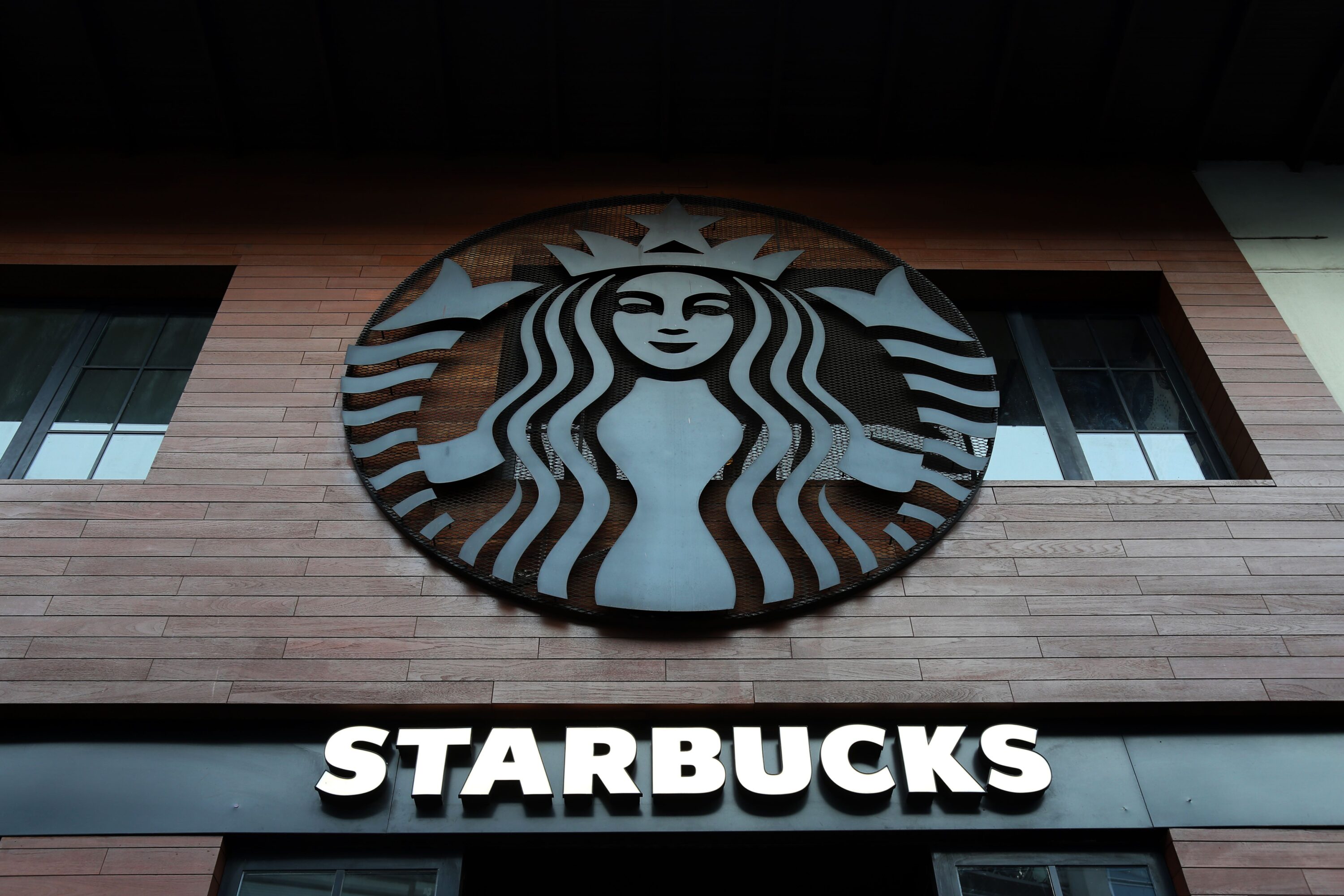 Low angle shot of Starbucks building exterior with logo and windows.